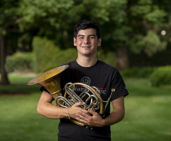 student holding French Horn