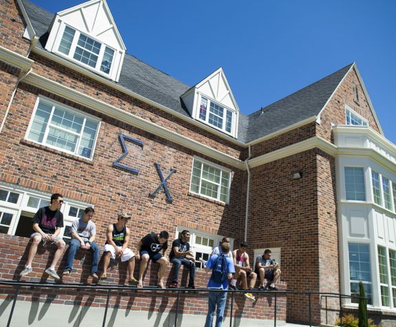 Sigma Chi brothers hanging out in front of house