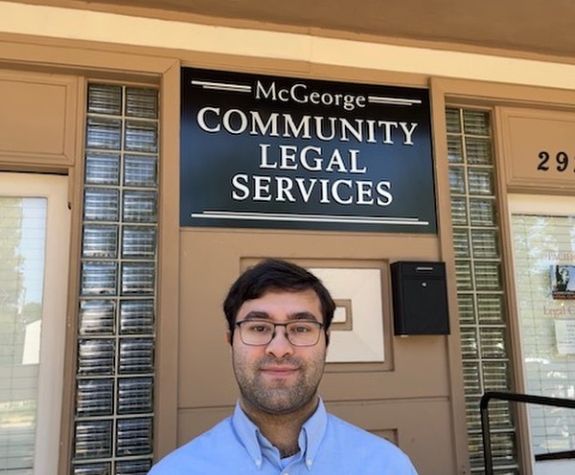 A man poses for a photo outside of a building