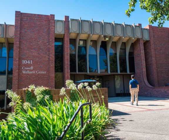 Image of a student walking towards the Cowell Wellness Center