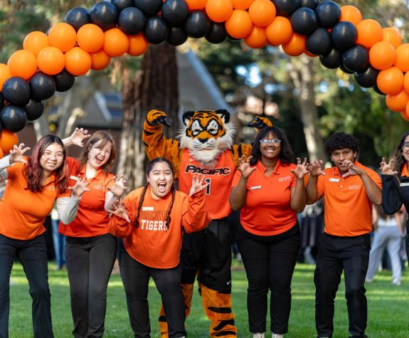 Admission ambassadors pose with the Powercat mascot under a balloon arch