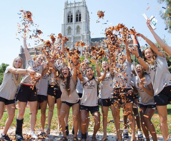 Many students cheering and throwing confetti