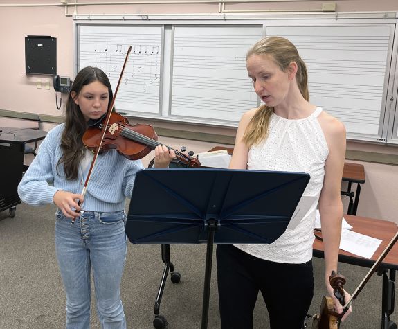 Professor Ann Miller gives a violin list to a first year student
