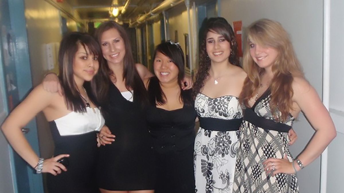 Five friends stand in a hallway in Southwest Hall. 