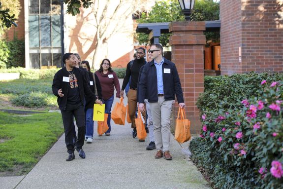 A student leads a tour group on campus