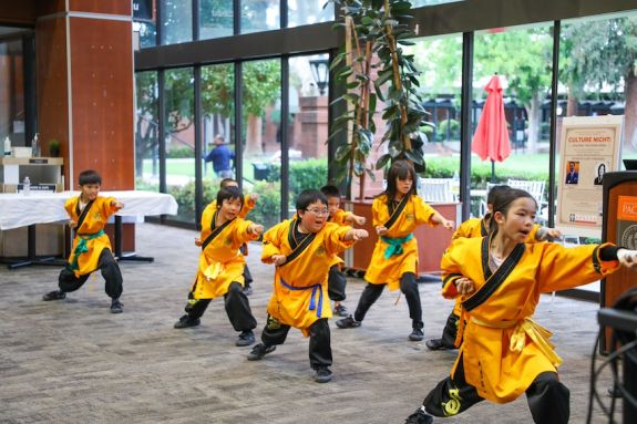 young children in traditional robes perform an act.