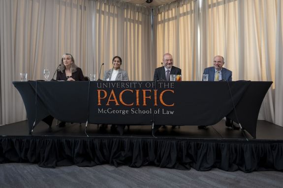 Four individuals speaking on a panel 