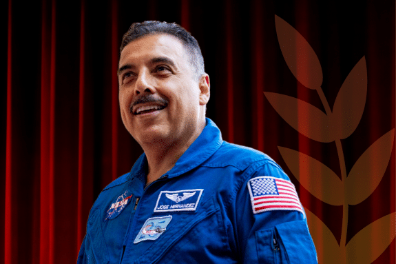 An image of Jose Hernandez in front of a dark red background 