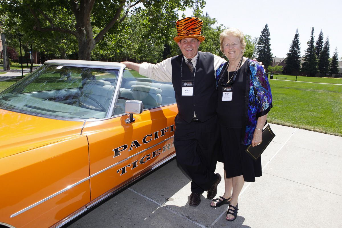Alumni posing with Pacific car