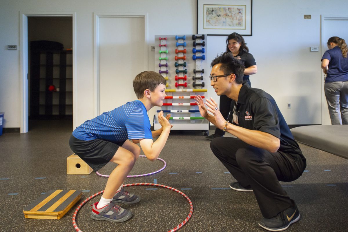 a physical therapy student works with a child during a clinic