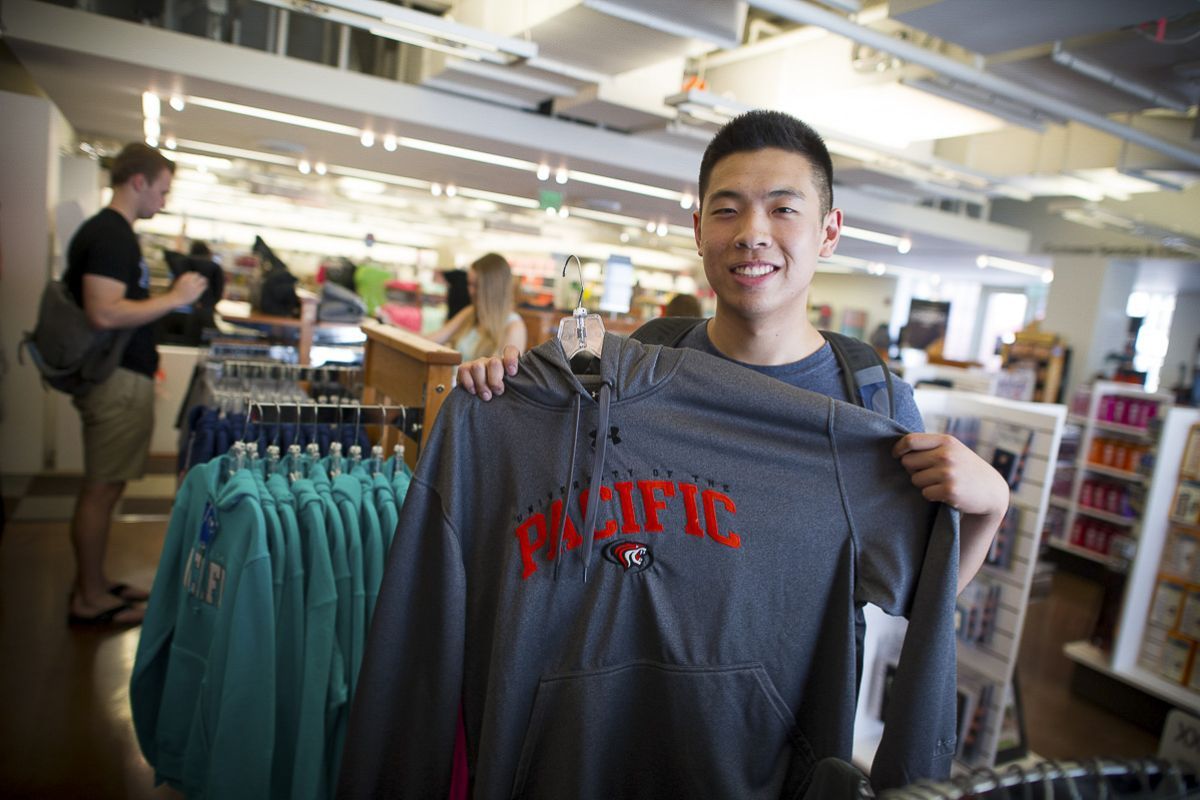 student holding up shirt in Stockton bookstore