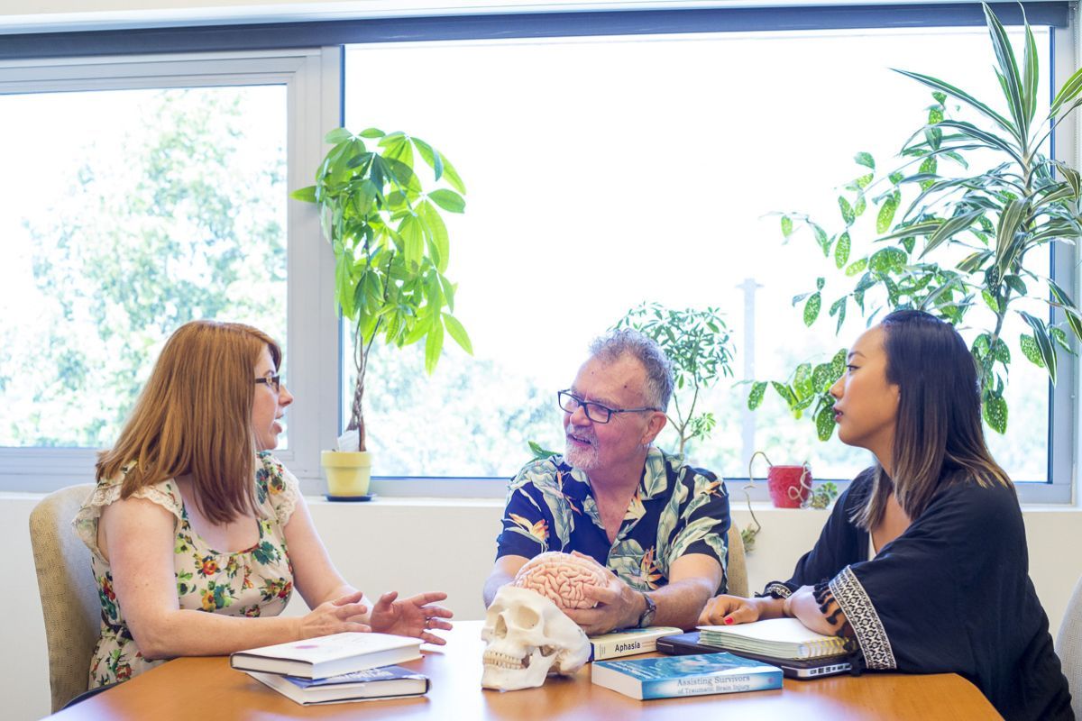 SLP professors talking around table