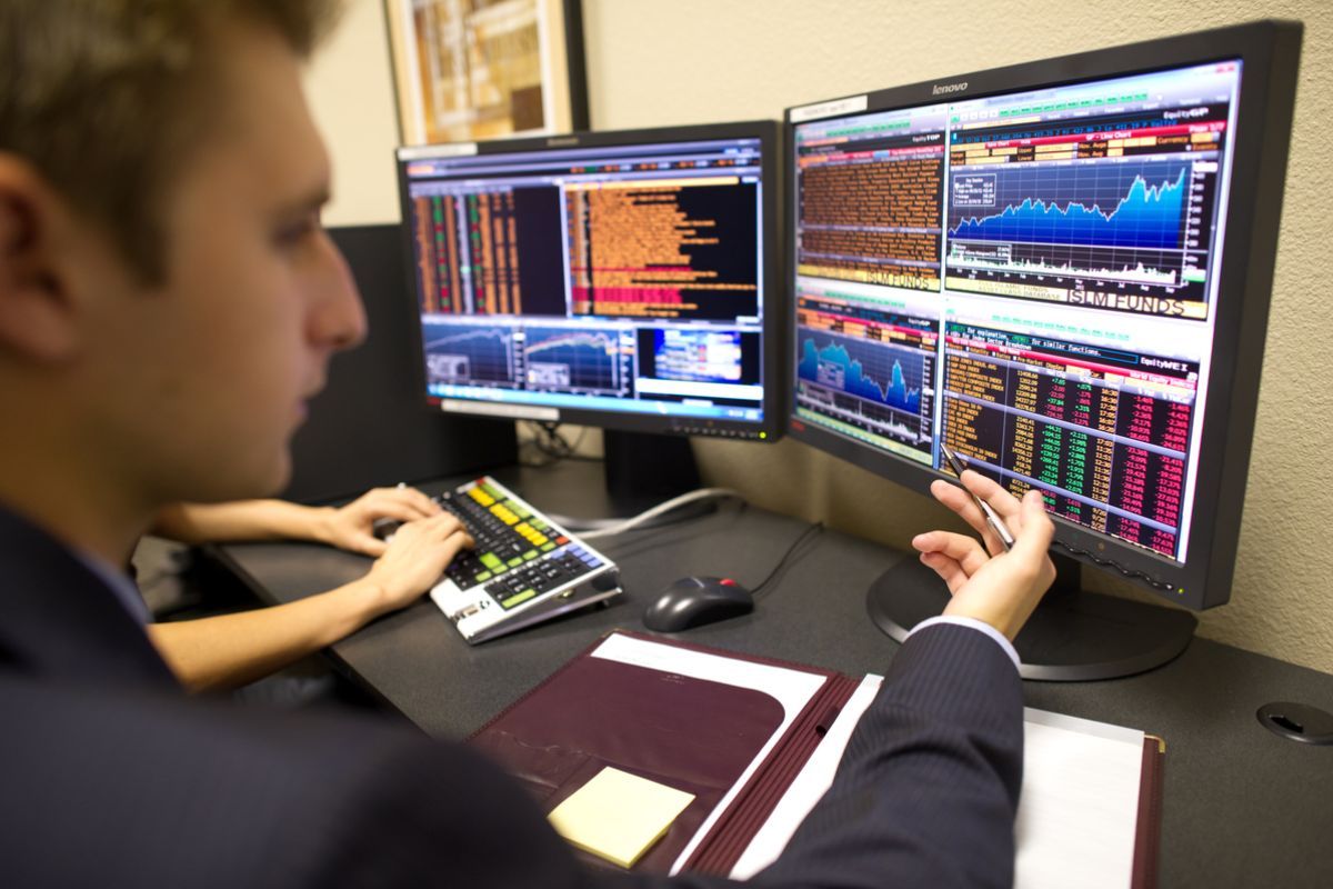 student looking at a screen analyzing stocks