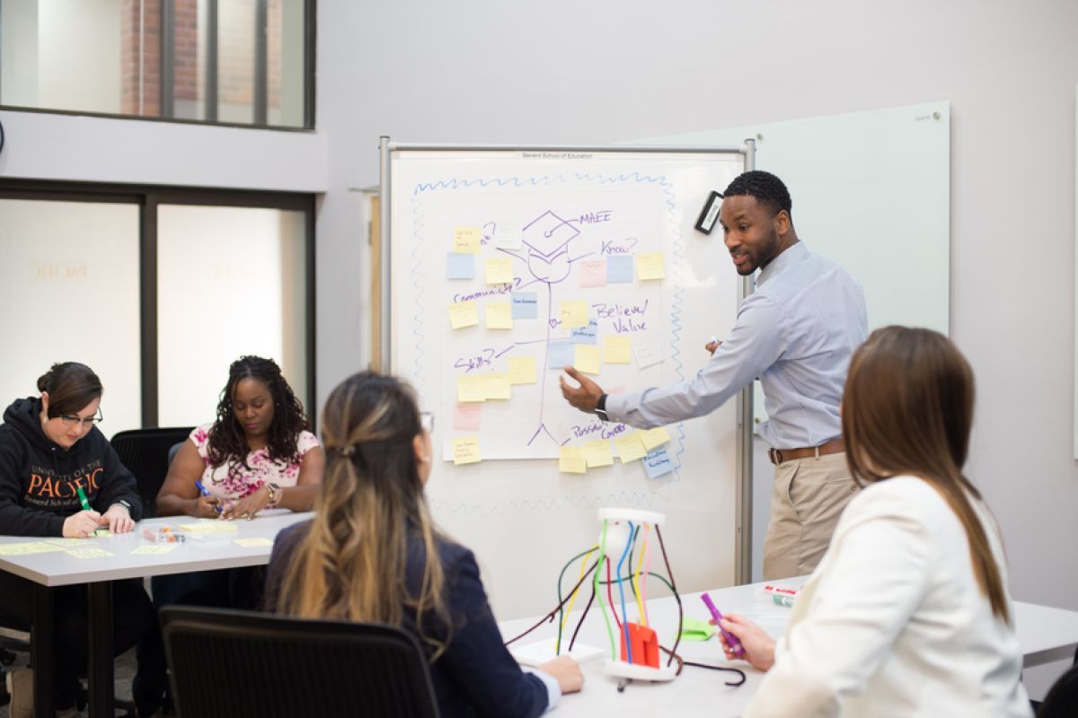 students interact with professor in classroom