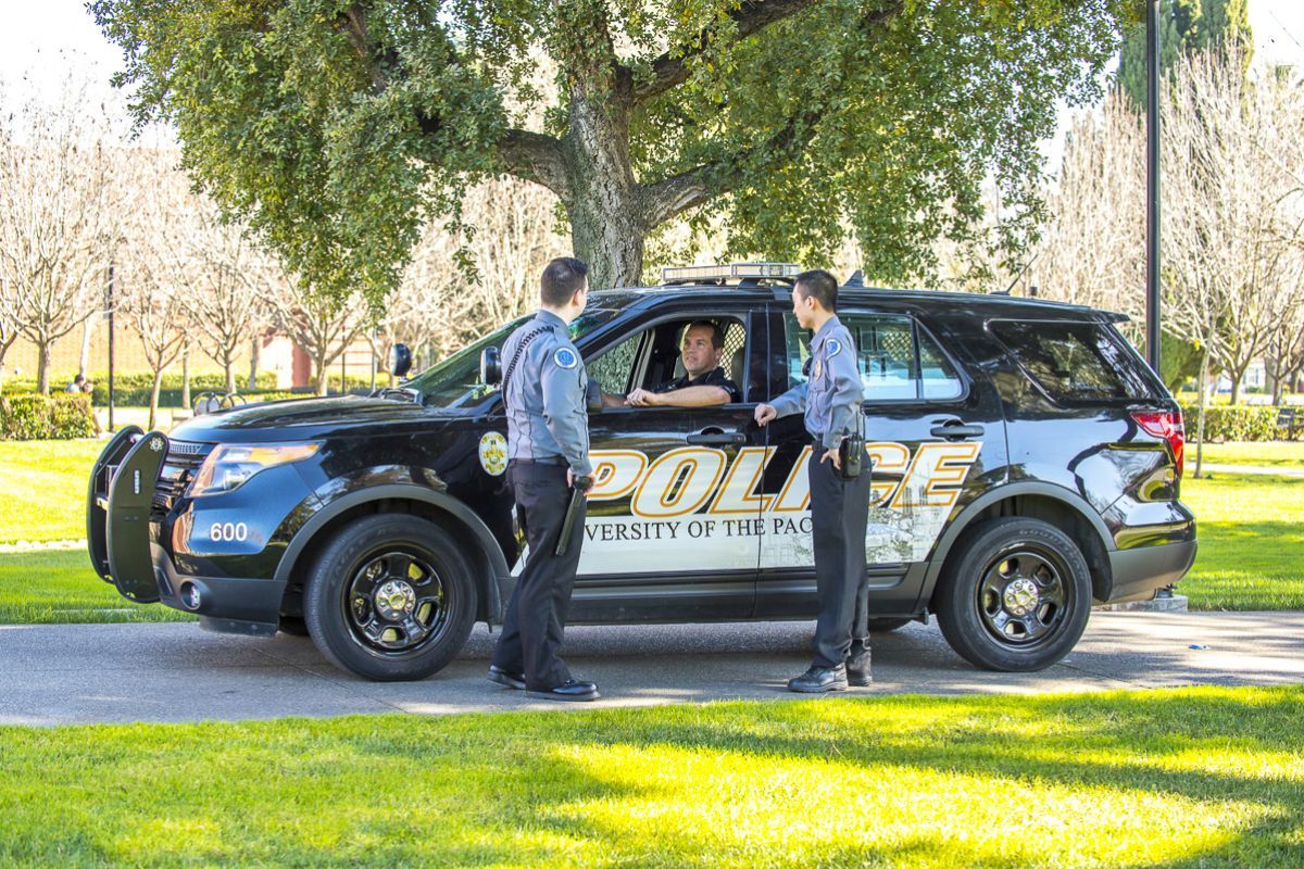 public safety employees gather by a vehicle