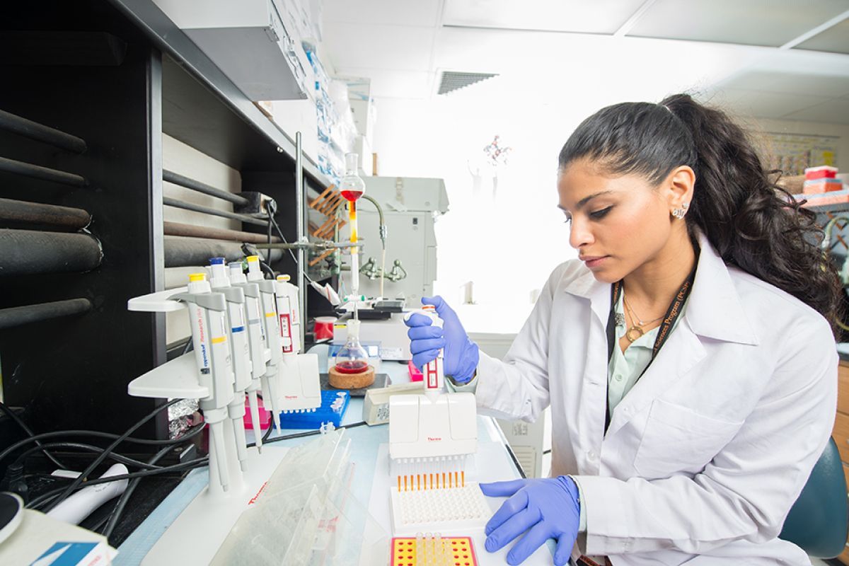 Student doing research holding a micropipette