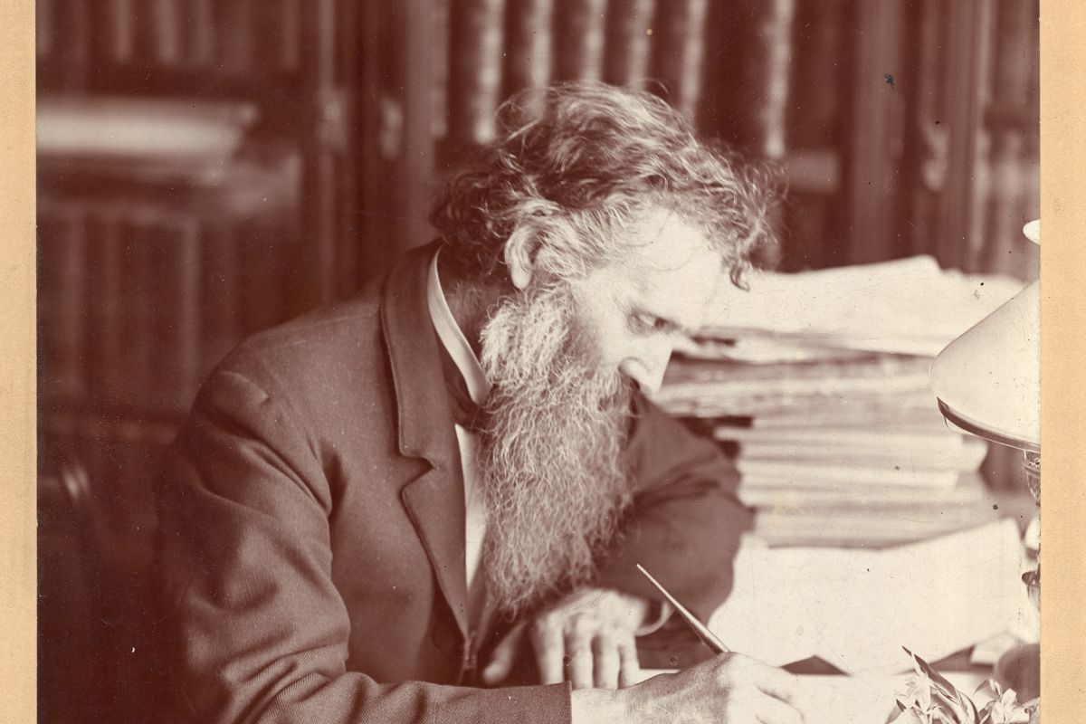 John Muir writing at a desk