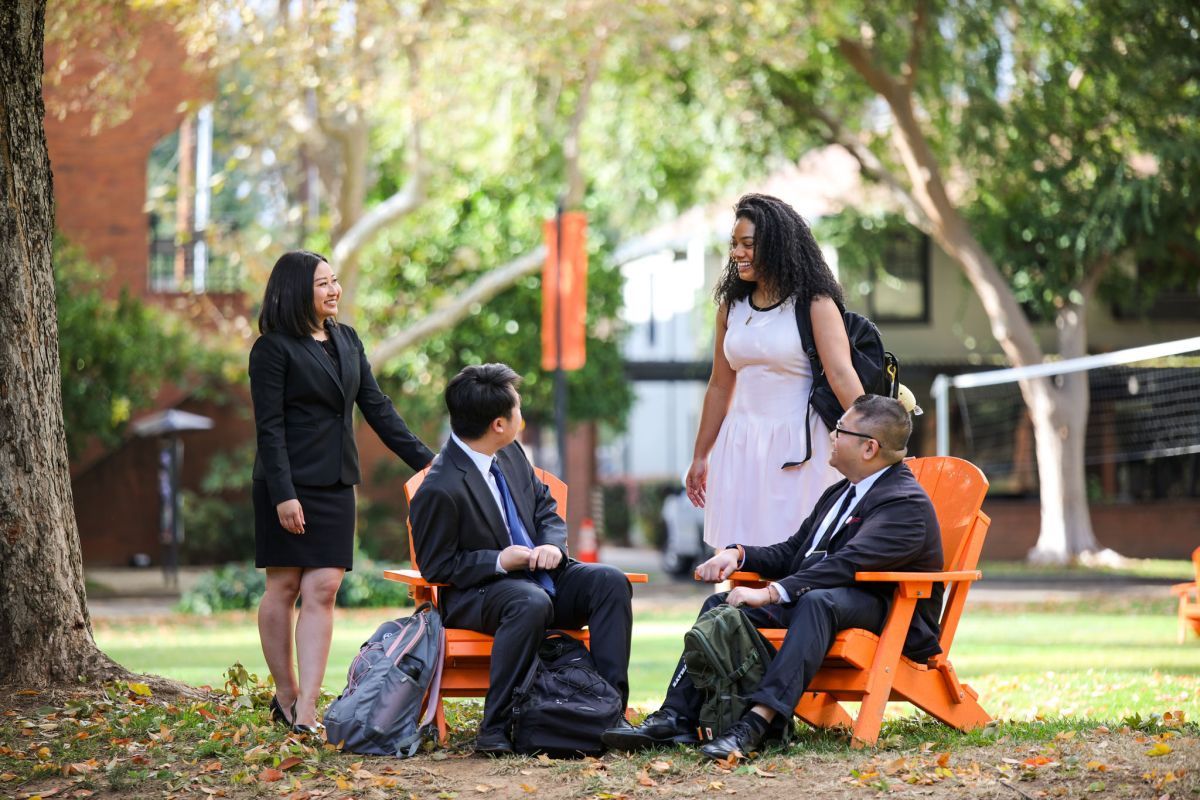 Four students sitting at McGeorge School of Law campus