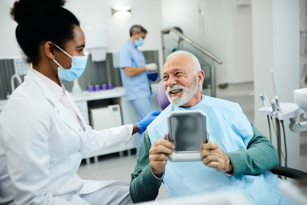 happy older man talking to dentist
