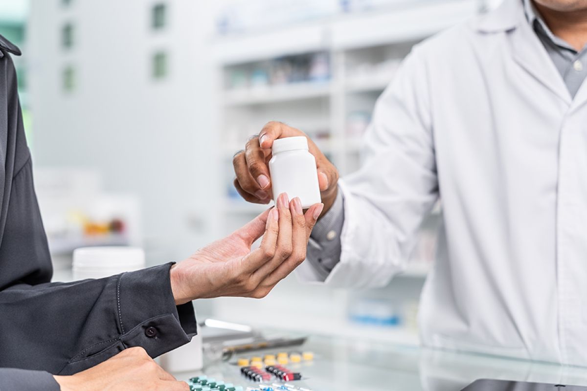 Close up shot of a patient interacting with a pharmacist at the counter
