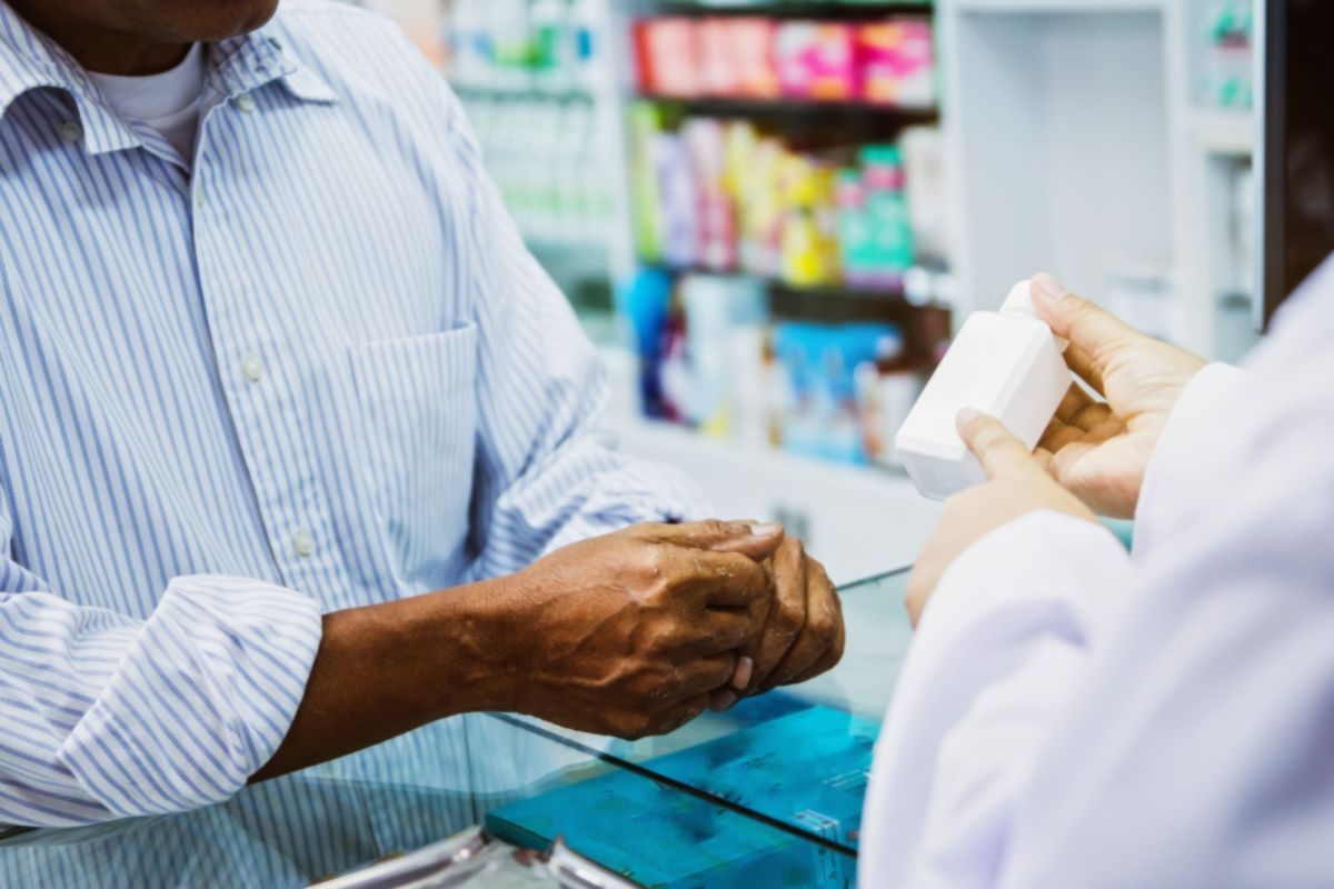 Close up shot of a patient interacting with a pharmacist at the counter