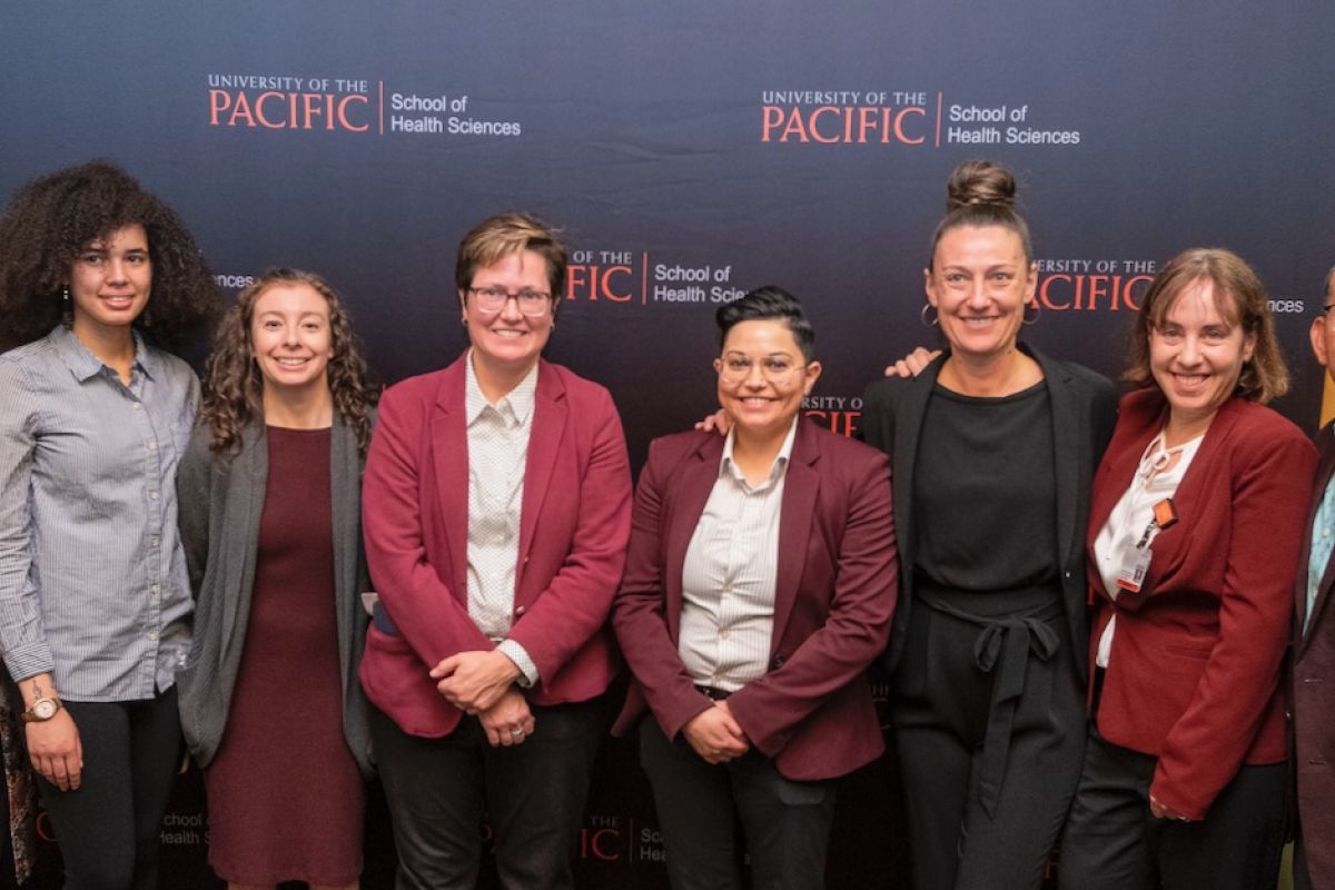Image features 9 faculty & staff members of the MSW program standing in a row.