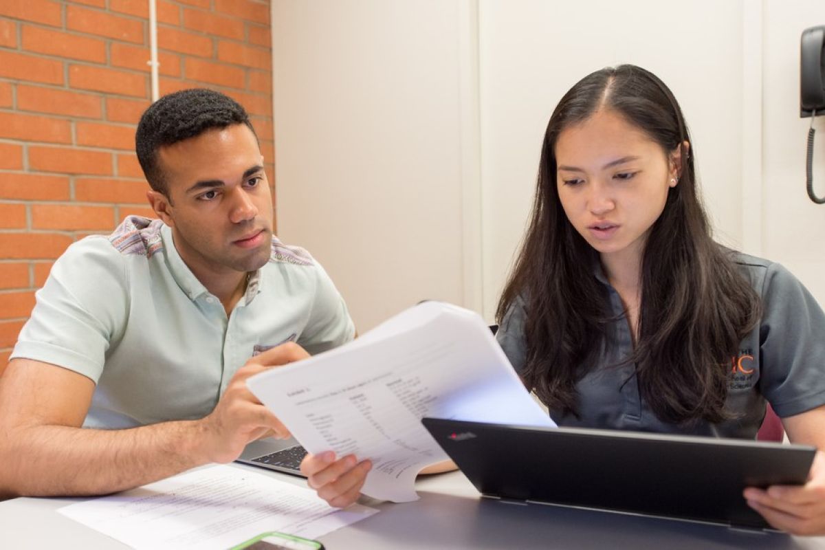 Photos shows two Pacific PA students looking at the screen on a laptop. 