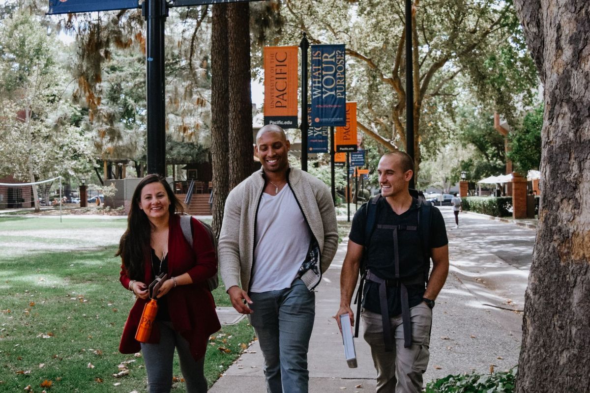 Photo shows three students walking on a sidewalk on Pacific's Sacramento campus. 