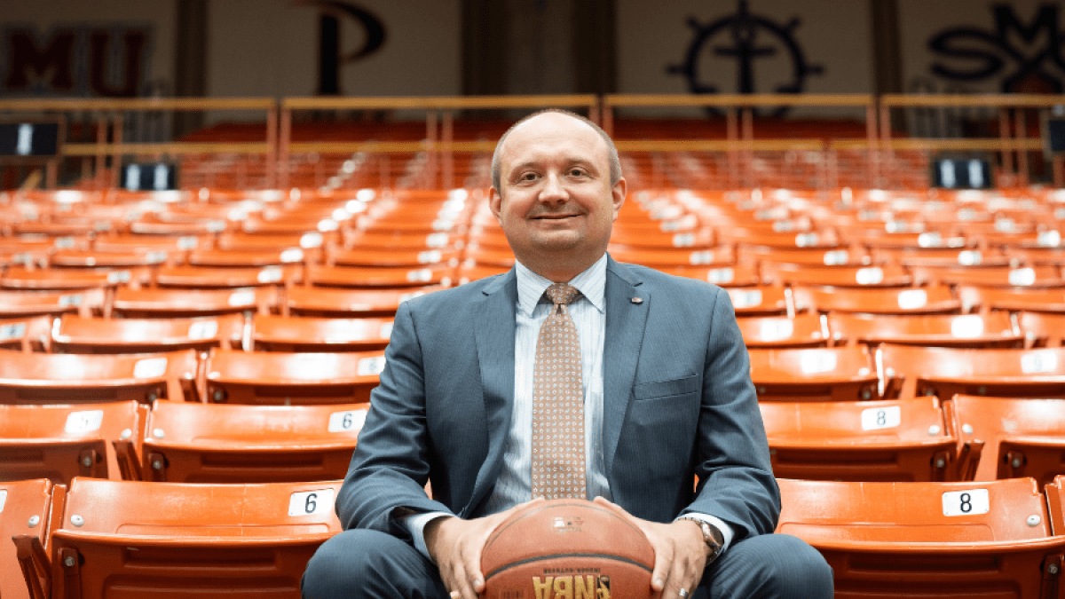 Adam Tschour sits in the stands among orange seats 