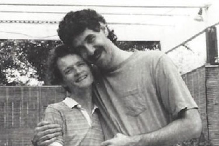 Two men embrace in a black and white photo