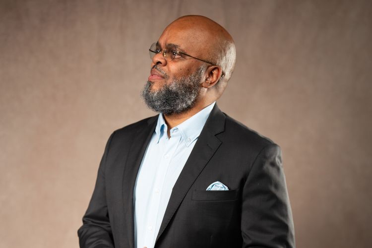 A portrait of a man wearing a suit looking off into the distance