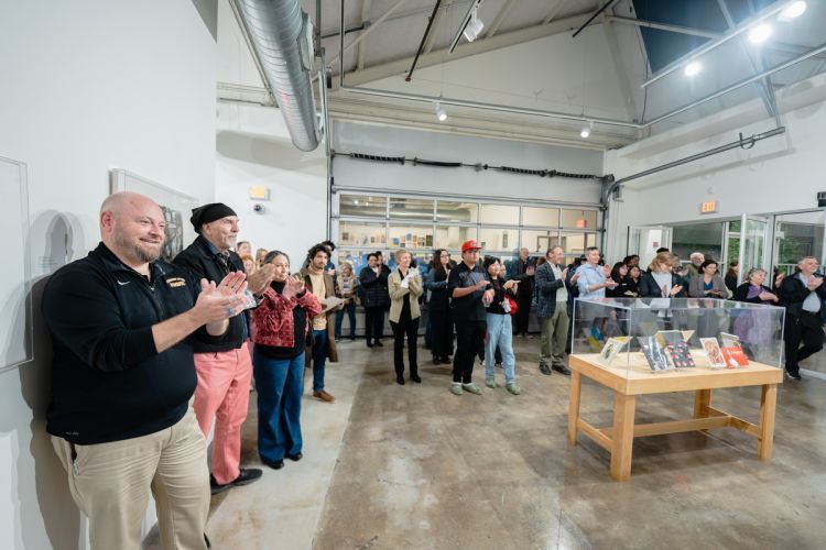Guests gather during the exhibition reception while the team behind the making of the exhibition introduces themselves. 