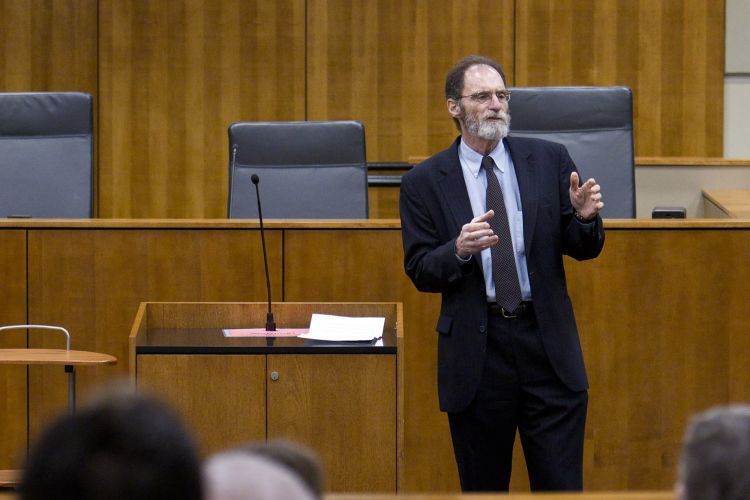 A man stands in a court room. 