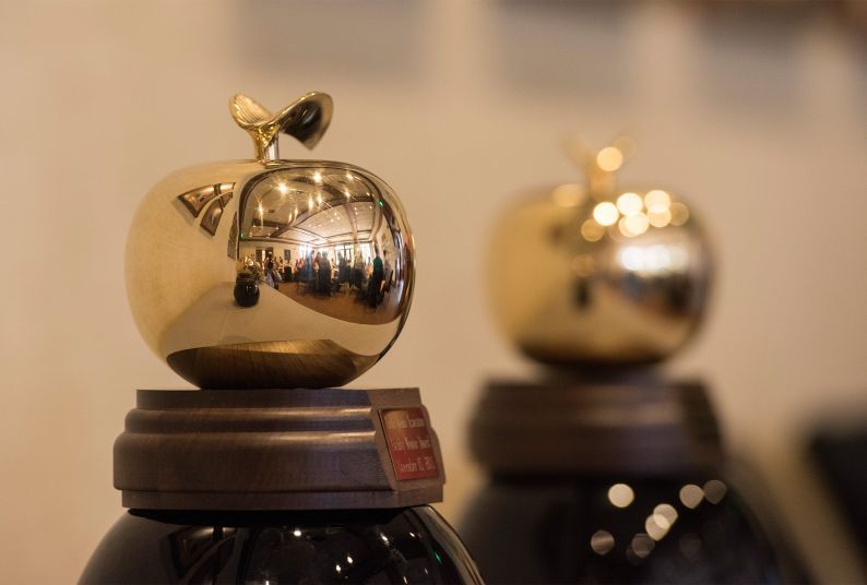 two awards in the shape of golden apples