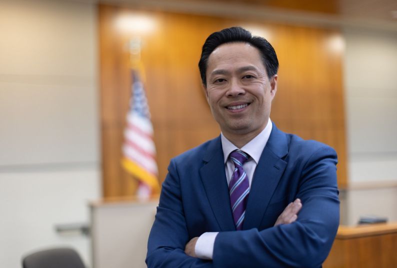 Photo of a man wearing a suit in a courtroom