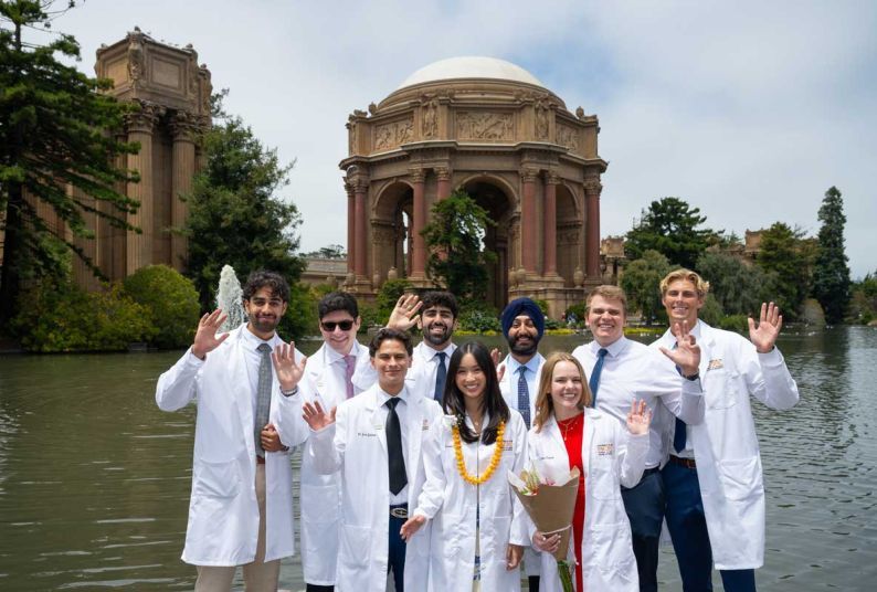 a group of students in their white coats in front of the Palace of Fine Arts
