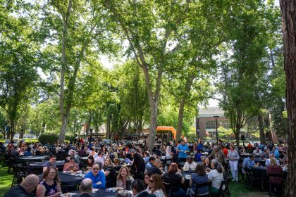 Staff and faculty sit at tables during a luncheon held outside on University of the Pacific's Stockton Campus.