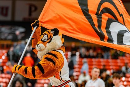 Powercat runs through the Spanos Center holding a flag with the Tigers logo