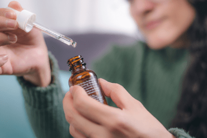 a woman holds a medicine dropper