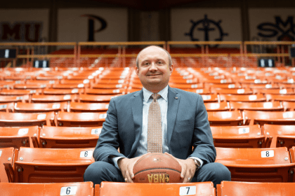 Adam Tschour sits in the stands among orange seats 