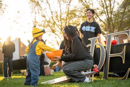 Student interacting with a child during Pacific Trick or Treat.