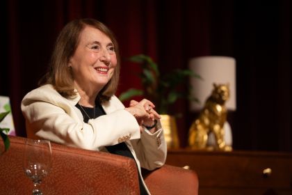 Cathy smiles in a beige blazer.