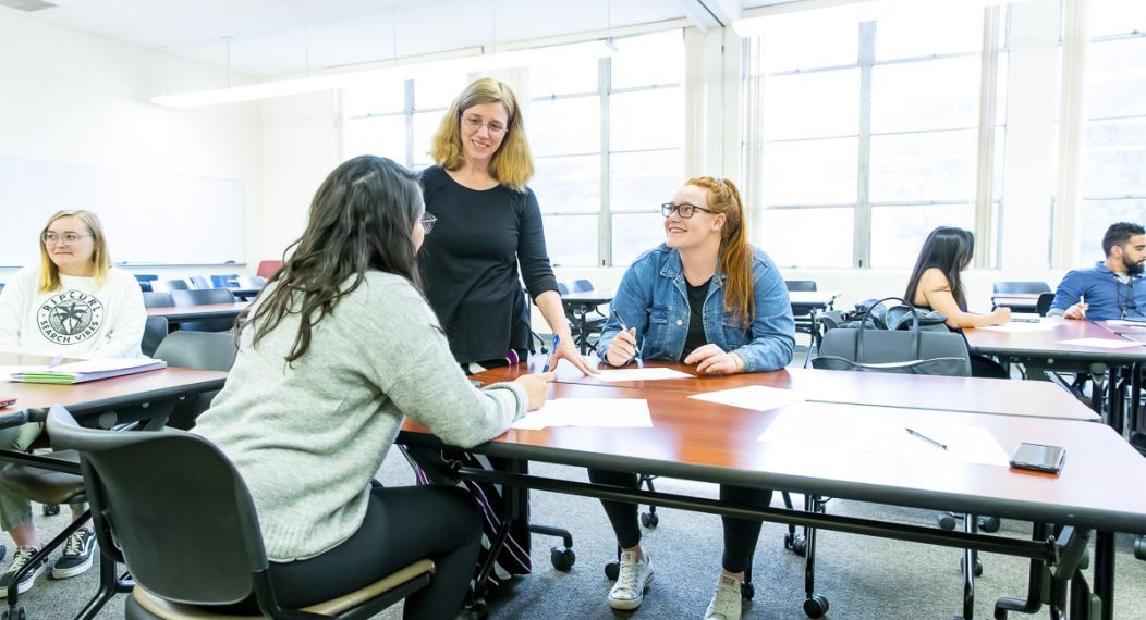 students interact with professor in classroom