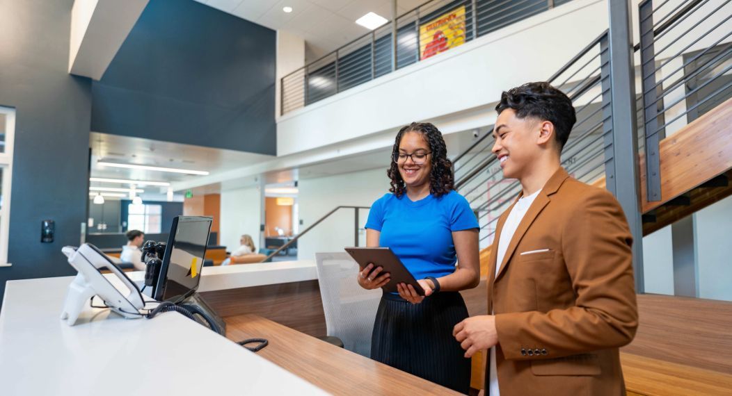 Two hospitality specialists at a reception desk 