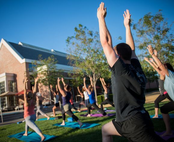 students doing yoga on DUC lawn