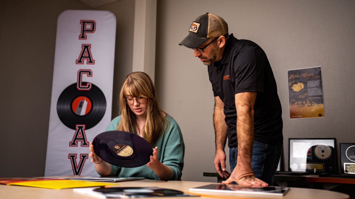 a professor and student look at music records